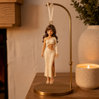 Custom figurine ornament displayed on a brass stand in a warm home